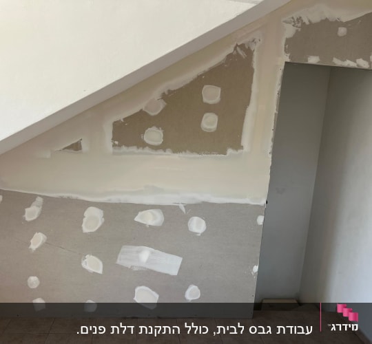 קיר גבס עם תיקונים מתחת למדרגות